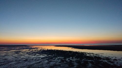 Scenic view of sea against clear sky during sunset