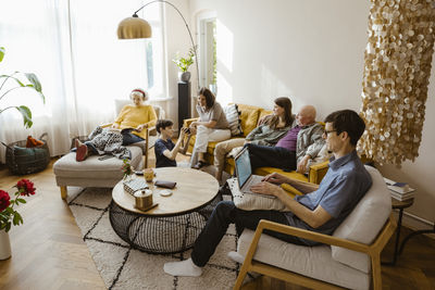 Rear view of woman sitting on sofa at home