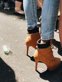 Low section of woman wearing high heels standing on road