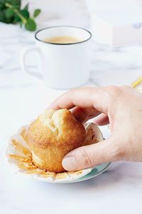 Woman's hand grabbing a homemade muffin.