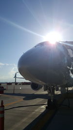 Airplane on airport runway against sky