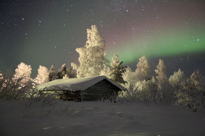 Scenic view of snow covered field against sky at night