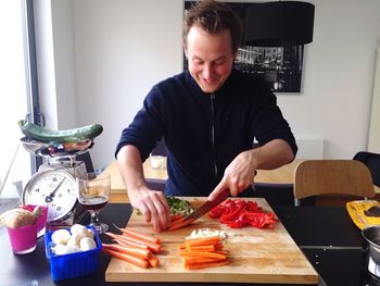 Happy chef chopping vegetables on cutting board