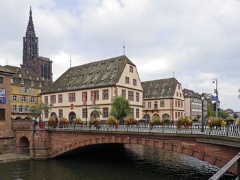 Bridge over river against buildings in city