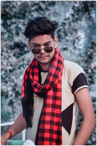 Portrait of young man wearing sunglasses standing outdoors