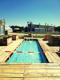 Swimming pool by building against clear blue sky