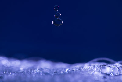 Close-up of bubbles against blue sky