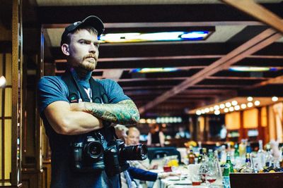 Photographer looking away while standing at restaurant