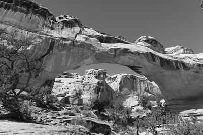 Rock formation by mountain against sky