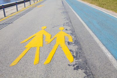 High angle view of yellow arrow sign on road
