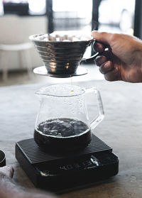 Barista holding a filter with espresso coffee inside straining. using a pod with coffee inside.