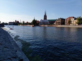 River amidst buildings in city against sky