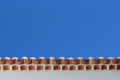 Close-up of wall and roof against clear blue sky