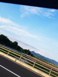 Road by mountain against sky