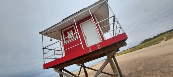Low angle view of lifeguard hut on beach against sky