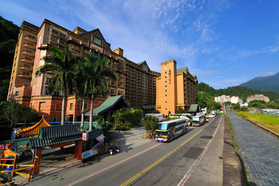 Cars on road against sky in city