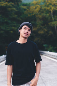 Portrait of young man wearing hat standing outdoors