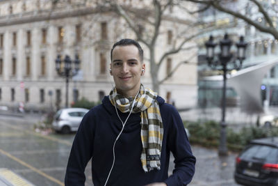 Portrait of young man standing in city