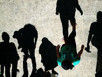 Directly above shot of people on footpath during sunny day