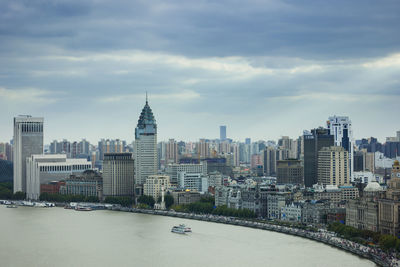 View of buildings in city against cloudy sky