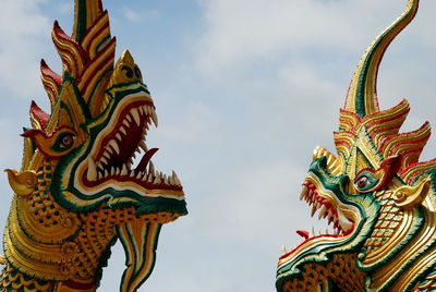 Low angle view of colorful dragon sculptures against sky