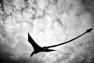 Low angle view of silhouette bird flying against sky