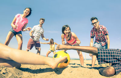 Group of people at beach against sky