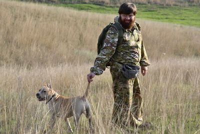 Full length of senior woman with dog on land