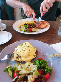 Midsection of man holding food in plate on table