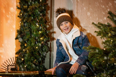 Young guy posing by the christmas tree on the street