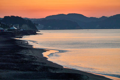 Scenic view of sea against orange sky during sunrise