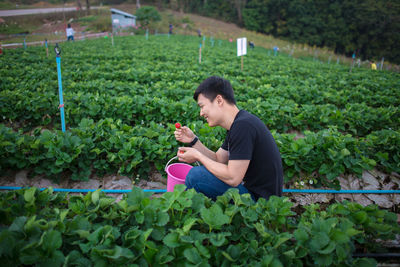 Side view of a man having food outdoors