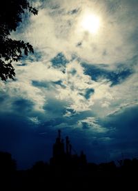 Low angle view of silhouette built structure against cloudy sky
