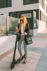 Full length of woman looking down while walking on tiled floor