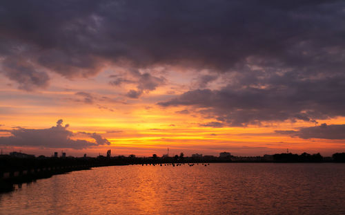 Scenic view of sea against dramatic sky during sunset