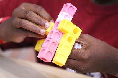Midsection of kid playing with toy block