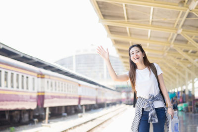 Full length of woman standing against train