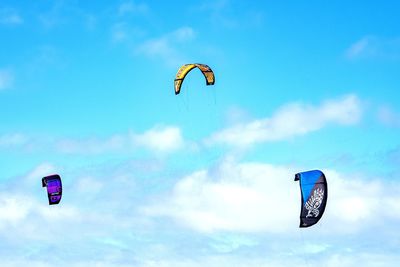 Low angle view of person paragliding against sky