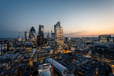 Aerial view of city lit up at sunset