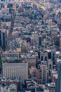 Aerial view of illuminated skyscraper buildings in city at day at high angle