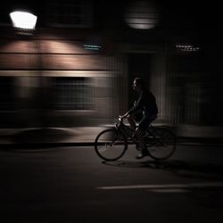 Blurred motion of people walking on road at night