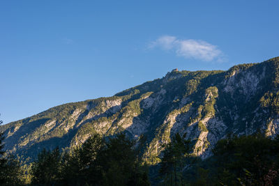 Low angle view of mountain against blue sky