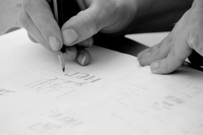 Cropped image of hand holding book on table