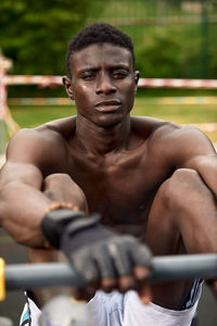 Portrait of shirtless man exercising in gym