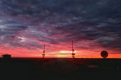 Silhouette landscape against dramatic sky during sunset