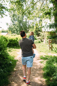 Rear view of man walking on field