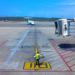 Airplane on airport runway against sky