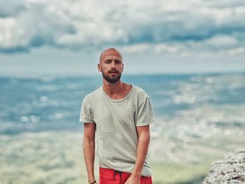 Portrait of young man standing at beach