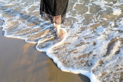 High angle view of woman standing in water at shore of beach