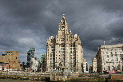 Low angle view of buildings against cloudy sky